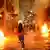 Homem corre por ruas com focos isolados de fogo, durante protesto organizado pelo Movimento Passe Livre (MPL) em São Paulo.