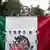 A protester holds up a Mexican flags with the pictures of the victims attached