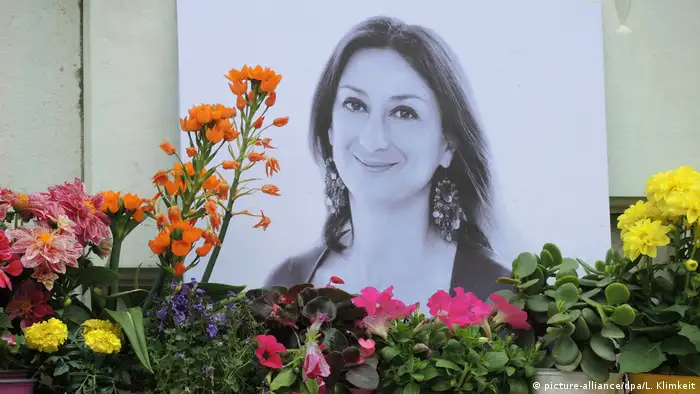 Colorful flowers and a black-and-white photo of Daphne Caruana Galizia