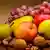 Nahaufnahme von Früchten, die beieinander liegen: Trauben, Äpfel, Birnen, dazu Walnüsse.