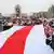 Протестующие в Минске натягивают бело-красно-белый флаг