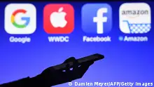 This photograph taken on September 28, 2017, shows a smartphone being operated in front of GAFA logos (acronym for Google, Apple, Facebook and Amazon web giants) as background in Hédé-Bazouges, western France. / AFP PHOTO / Damien MEYER (Photo credit should read DAMIEN MEYER/AFP via Getty Images)