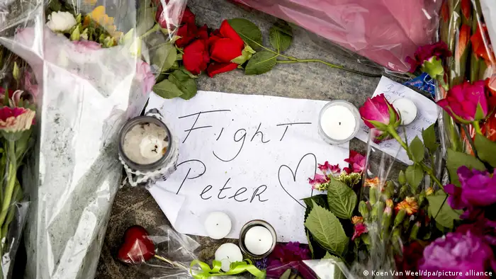 Flowers and candles surround a note that says Fight Peter, illustrated with a heart 
