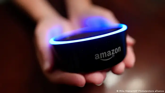 Picture of two hands holding an Amazon Alexa Echo Dot speaker.