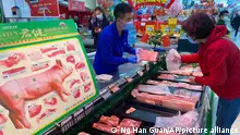 An employee attends to a customer at a supermarket in Beijing, China, Wednesday, Nov. 3, 2021. A recent seemingly innocuous government recommendation for Chinese people to store necessities for an emergency quickly sparked scattered instances of panic-buying and online speculation of imminent war with Taiwan. (AP Photo/Ng Han Guan)