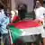 An anti-coup protester in Khartoum holding up a Sudanese flag