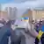 Pessoas num protesto empunhando bandeiras da Ucrânia e cartazes