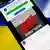 Symbolbild Fake-News im Ukraine-Krieg: Über einer Nachricht auf einem Handy steht dick "Fake". Im Hintergrund sieht man eine ukrainische und eine russische Flagge
