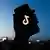 A symbolic image of the TikTok logo displayed on a phone screen and a view of a city blurred in the background