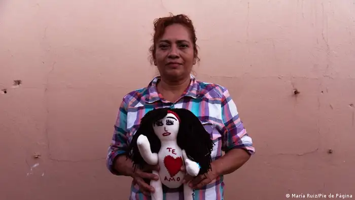 Rosalba Rojas holds a doll she made representing her disappeared loved one.