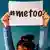 A woman holds up a sign that reads "#metoo"