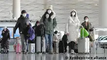 27.12.2022+++ Passengers wearing face masks pull baggage at a departure lobby in Beijing Capital International Airport on Dec. 27, 2022, after the central government recently dropped its zero-COVID policy. (Kyodo)