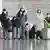 Passengers wearing face masks pull baggage at a departure lobby in Beijing Capital International Airport