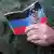 A man holds a Donetsk People's Republic document in his hand