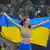 Yaroslava Mahuchikh holding up the Ukrainian flag behind her