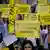 Protesters hold up signs by Amnesty International reading "We stand with women of Iran"