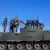 Boris Pistorius (SPD, M), Bundesminister der Verteidigung, steht zusammen mit Generalleutnant Martin Schelleis (l), Inspekteur der Streitkräftebasis, auf einem Fahrschulpanzer vom Typ Leopard 2.