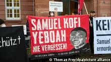Demonstranten stehen am 16. November 2022 beim Auftakt eines Prozesses um einen tödlichen Brandanschlag auf ein Asylheim in Saarlouis 1991 vor dem Oberlandesgericht Koblenz. Nun könnte ein Deal das langwierige Verfahren verkürzen. - (zu dpa Gericht schlägt Deal im Mordprozess um Asylheim-Brand vor) +++ dpa-Bildfunk +++