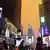  Personas con mascarilla caminan por las calles de Nueva York. El cielo se ve naranja.