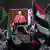 Transmissão em direto em Haia, enquanto manifestantes pró-palestinianos protestam junto ao Tribunal Internacional de Justiça, no dia em que os juízes ouvem um pedido de medidas de emergência feito pela África do Sul para que Israel pare as ações militares em Gaza