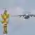 Ein Flugzeug vom Typ A-50 fliegt an einer goldenen Statue auf dem roten Platz in Moskau vorbei