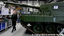 （肖尔茨从坦克前经过照片）2024年2月，德国总理肖尔茨参观军火公司莱茵金属（Rheinmetall）