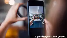 Hands of businesswoman photographing circular equipment through smart phone in office model released, Symbolfoto property released, JOSEF16819