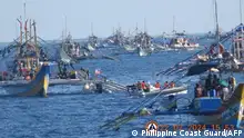 菲律宾一艘充气船（左中）正在斯卡伯勒浅滩（中称黄岩岛）附近向渔民运送补给