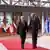 Antonio Guterres und Charles Michel gehen vorbei an Flaggenparade im Brüsseler Ratsgebäude über den roten Teppich