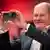 German Chancellor Olaf Scholz holding up an black iPhone
