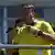 El expresidente brasileño, con la camiseta de la selección nacional, gesticula micrófono en mano.